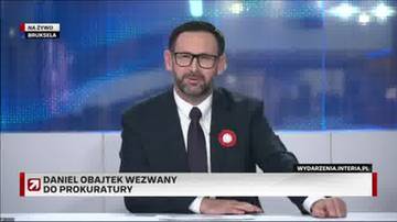 Daniel Obajtek w garniturze i krawacie siedzi przy stole, z tyłu ekran z niebieskimi pikselami, na dole grafika z informacją o wezwaniu do prokuratury.