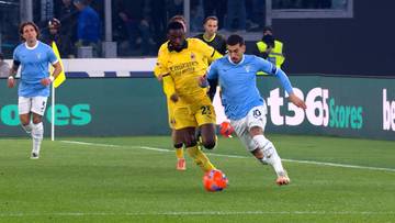 Piłkarz w żółtej koszulce z numerem 23 próbuje odebrać piłkę piłkarzowi w niebieskiej koszulce podczas meczu piłkarskiego.