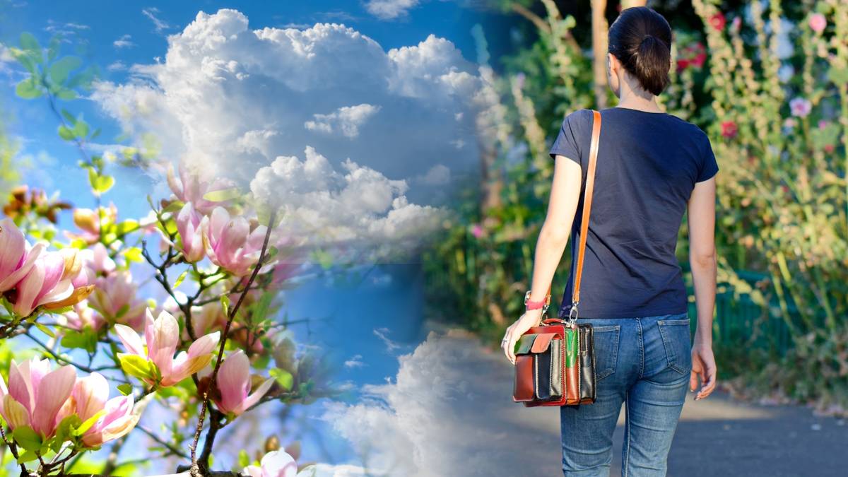 Kobieta idąca ścieżką wśr&oacute;d zieleni, po lewej stronie widok na kwitnące drzewo magnolii i niebo z chmurami.
