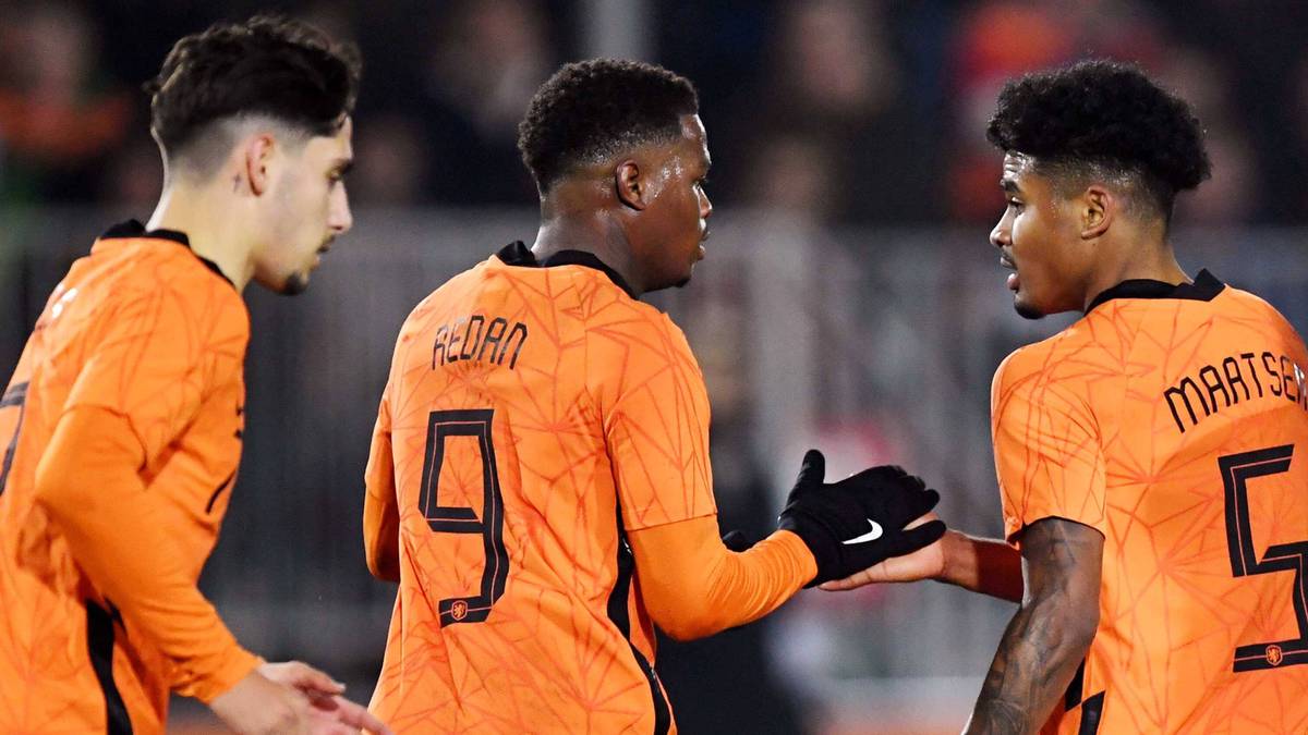 Trzech piłkarzy w pomarańczowych strojach reprezentacji Holandii.