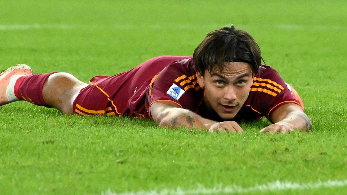 Piłkarz AS Roma Paulo Dybala leży na murawie stadionu.