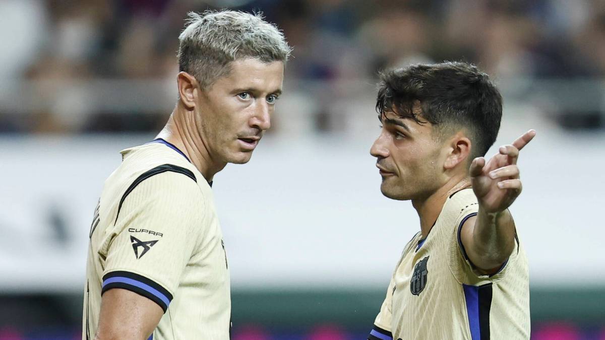 Dwóch piłkarzy FC Barcelony w żółtych koszulkach, jeden wskazuje palcem.