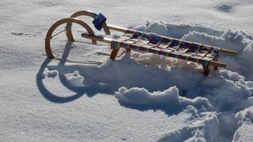Drewniane sanki leżące na śniegu.