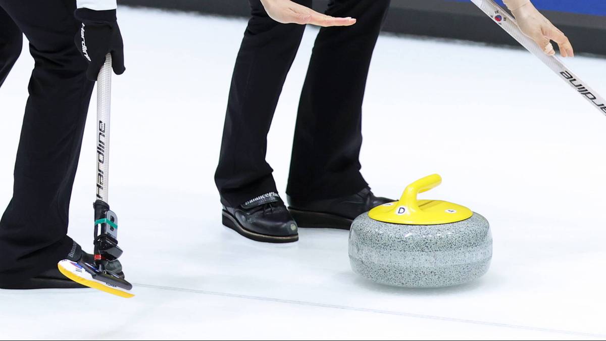 Dwie kobiety w strojach curlingowych wykonują rzut kamieniem na lodowisku.