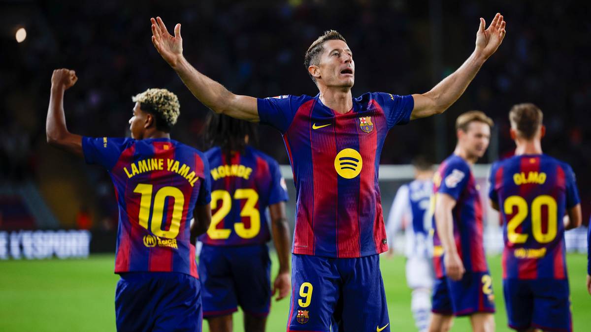 Robert Lewandowski w barwach FC Barcelony świętuje bramkę, z innymi zawodnikami w tle.