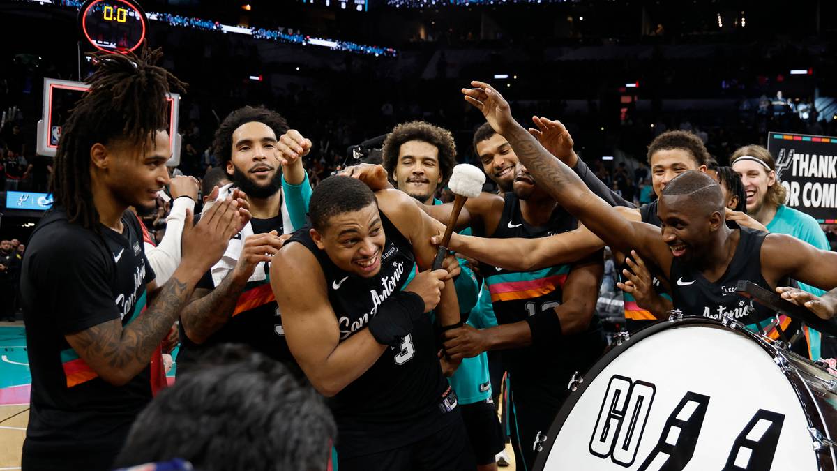 Koszykarze San Antonio Spurs świętują, jeden z zawodnik&oacute;w jest otoczony przez koleg&oacute;w z drużyny.