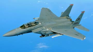 Amerykański myśliwiec F-15E w locie na tle błękitnego nieba.