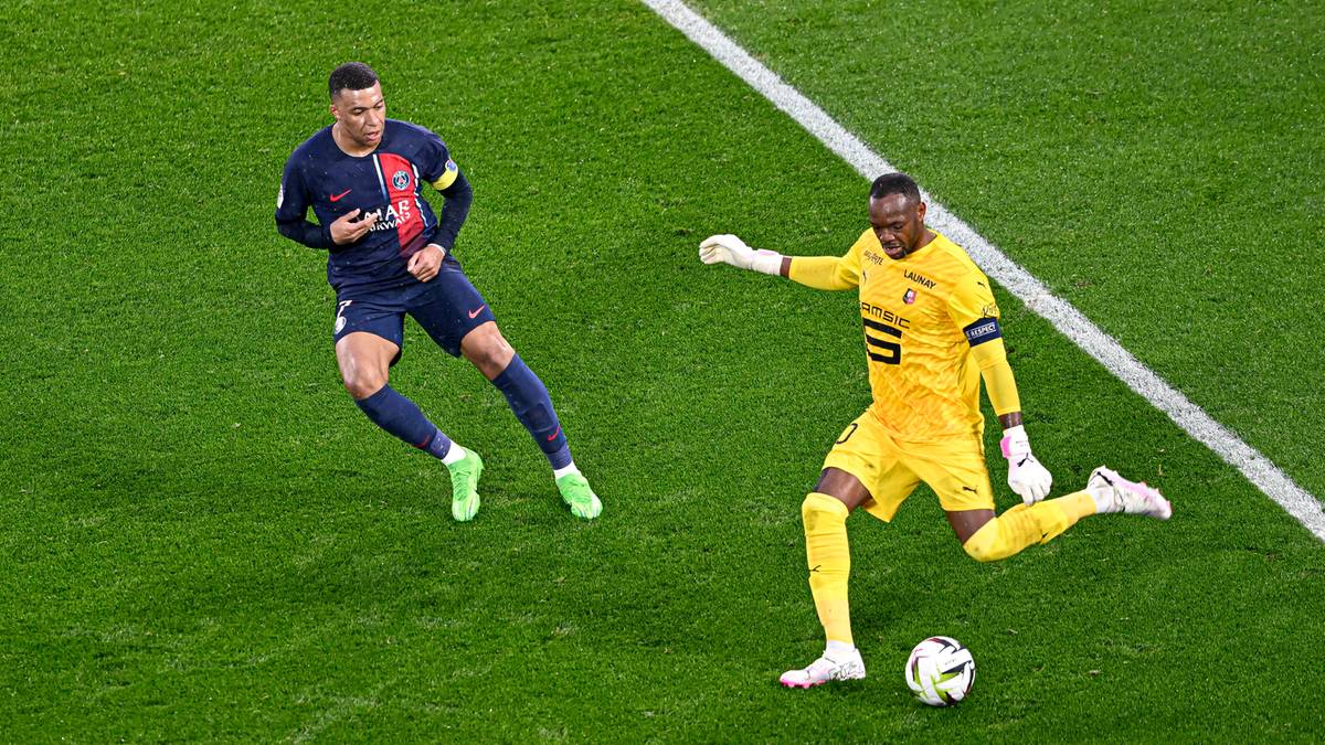 Dwóch piłkarzy na boisku piłkarskim. Jeden w granatowo-czerwonym stroju, drugi w żółtym.