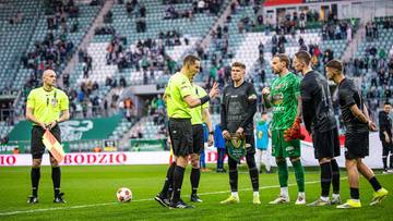 Piłkarze Śląska Wrocław i sędzia na murawie stadionu przed meczem z Wisłą Krak&oacute;w.