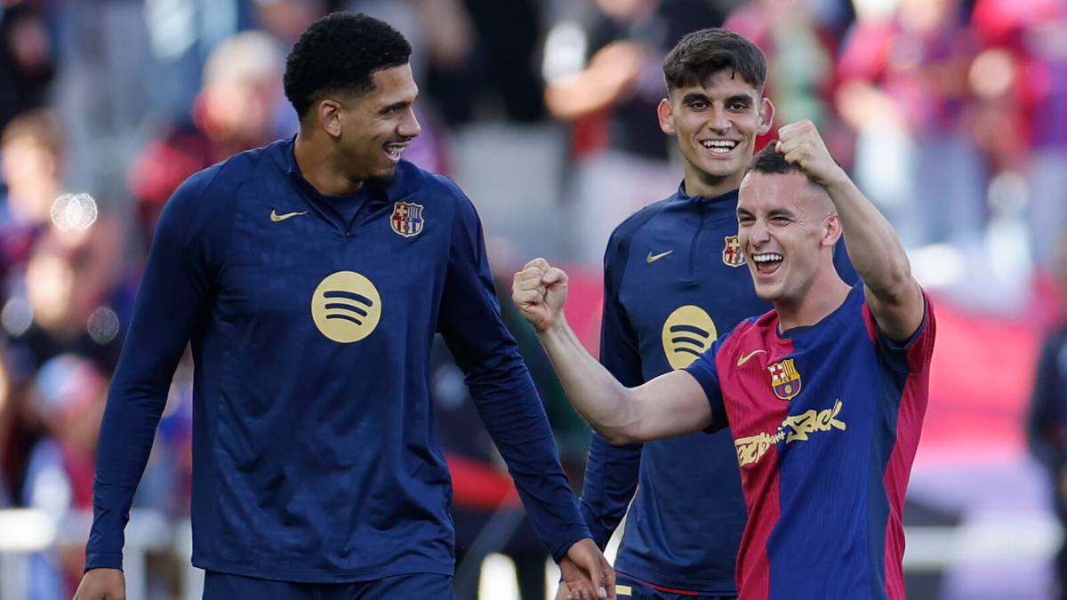 Trzech piłkarzy FC Barcelony świętujących na boisku.