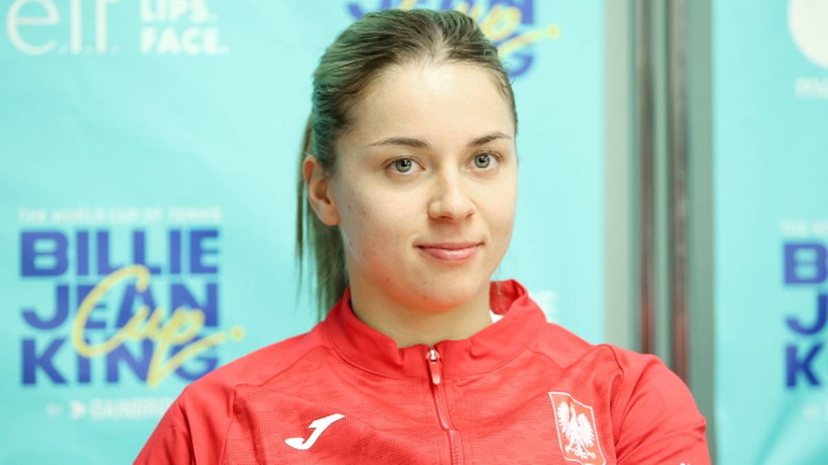 Portret młodej kobiety w stroju sportowym na tle logo Billie Jean King Cup.