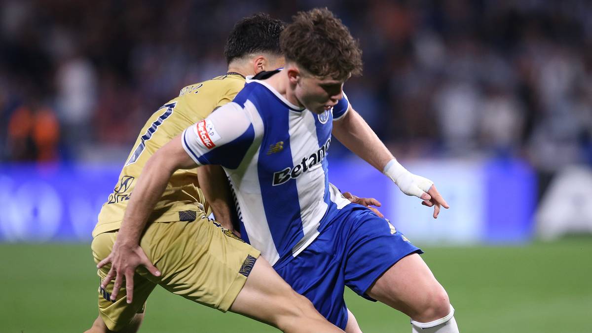 Dwóch piłkarzy w akcji na boisku, jeden w niebiesko-białej koszulce, drugi w żółtym stroju, walczą o piłkę.