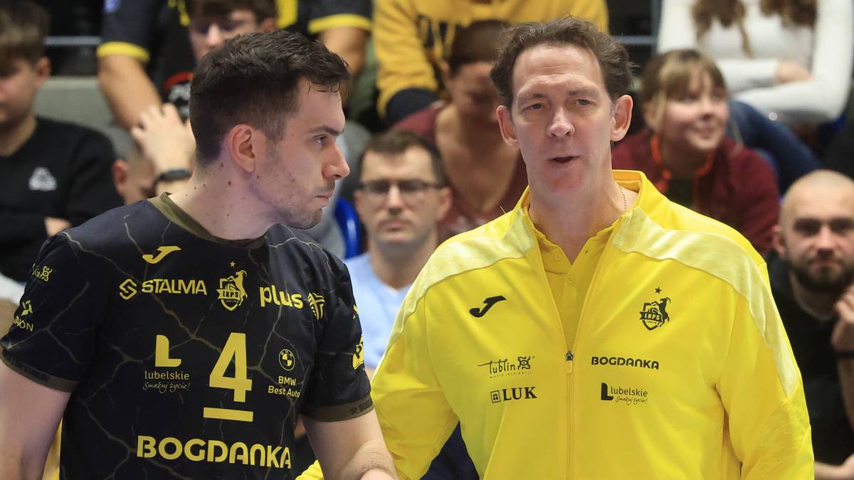 Dw&oacute;ch siatkarzy w strojach sportowych, jeden w czarnej koszulce z numerem 4, drugi w ż&oacute;łtej kurtce.