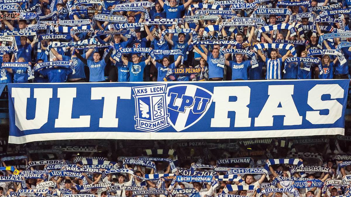 Tłum kibic&oacute;w w niebieskich strojach z szalikami, z transparentem "ULTRAS" na trybunie stadionu.