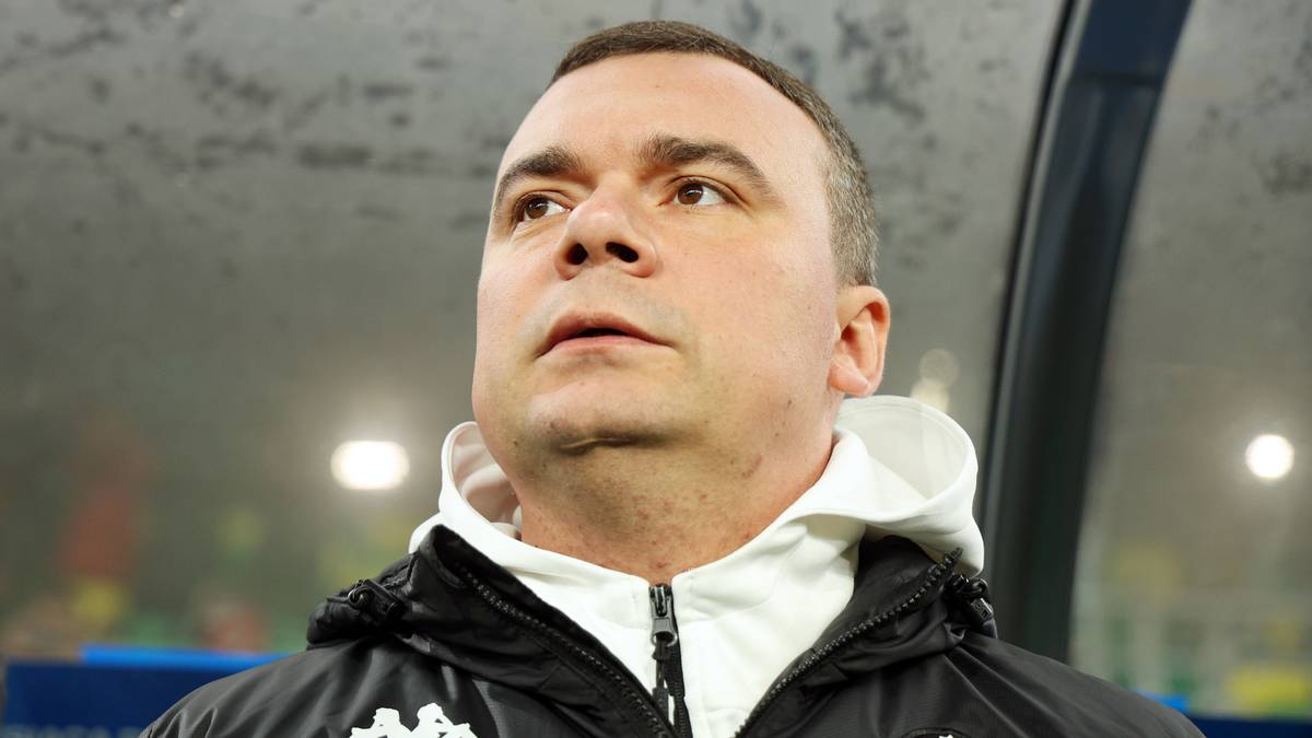 Adrian Siemieniec, trener Jagiellonii Białystok, patrzy w górę.