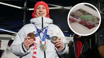 Uśmiechnięty Kacper Tomasiak w zimowej kurtce i czapce prezentuje trzy medale olimpijskie.