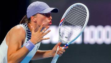 Iga Świątek z rakietą tenisową i czapką na głowie wykonuje gest ustami.