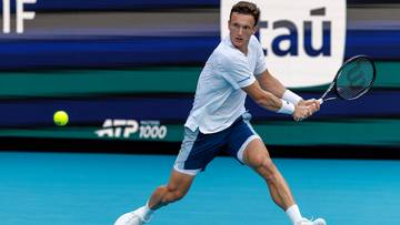 Tenisista wykonujący uderzenie forhendowe na korcie tenisowym, z widocznym logo ATP 1000 w tle.