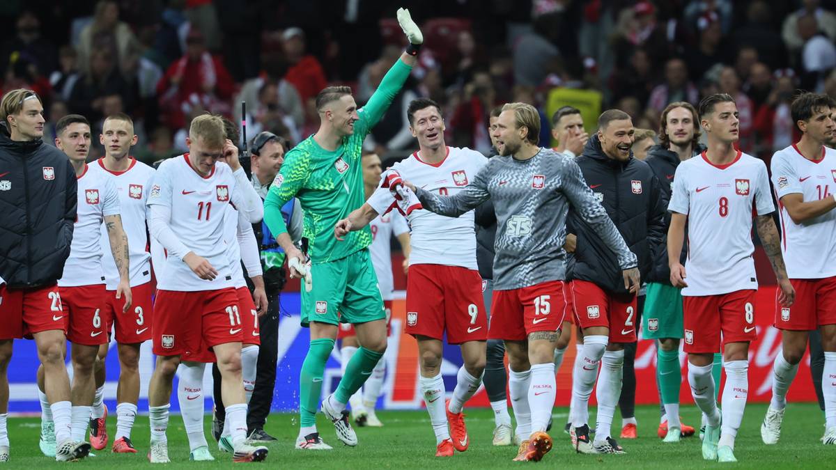 Piłkarze reprezentacji Polski w strojach meczowych cieszą się na boisku po wygranej.