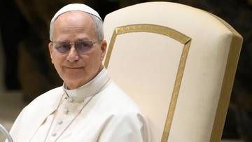 Papież Leon XIV w stroju papieskim siedzi na krześle.