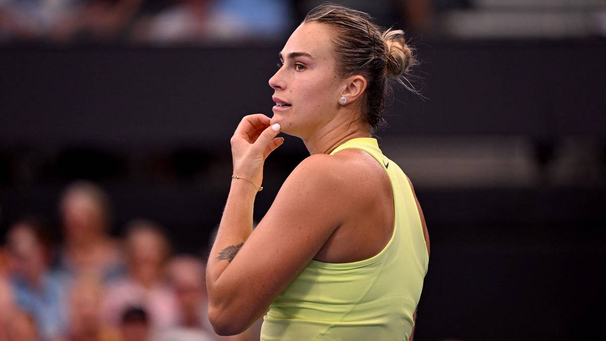 Zawodniczka tenisa w ż&oacute;łtej koszulce podczas meczu, z ręką przy twarzy.