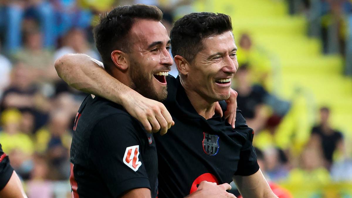 Trzech piłkarzy FC Barcelony świętuje na boisku.