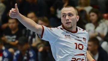 Mężczyzna w białej koszulce sportowej z numerem 10 pokazuje kciuk w g&oacute;rę.