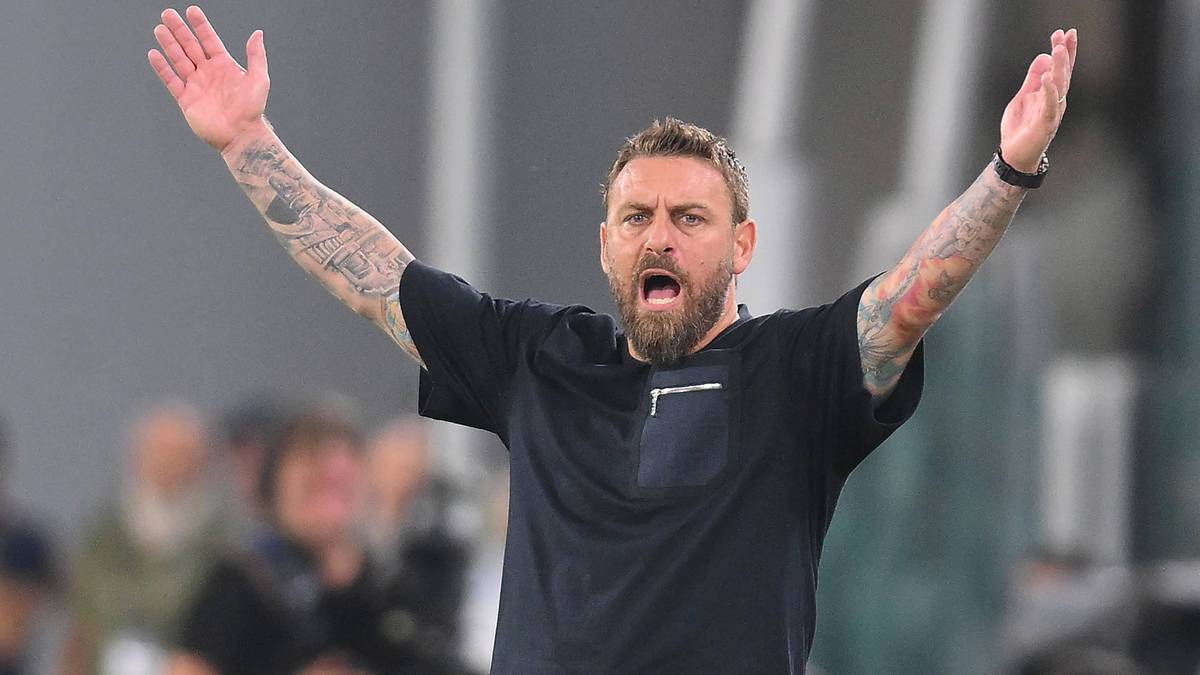 Daniele De Rossi, trener, z rękami rozłożonymi na boki i otwartymi ustami.