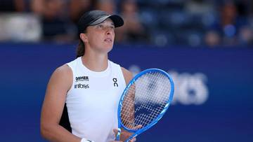 Iga Świątek podczas meczu tenisowego, z rakietą w ręku i skupionym wyrazem twarzy.