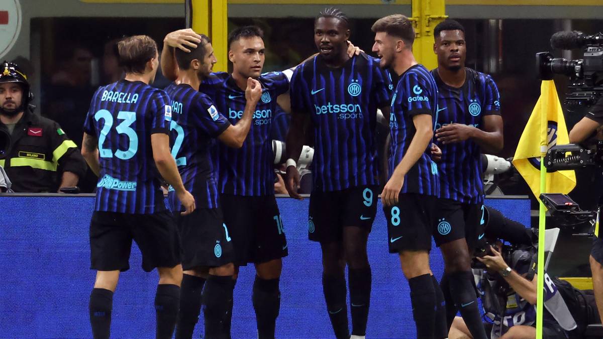 Pięciu piłkarzy Interu Mediolan w niebiesko-czarnych strojach świętuje zwycięstwo na boisku.