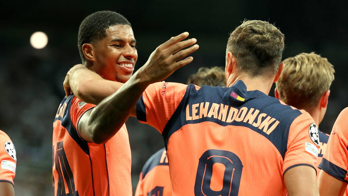 Piłkarz Marcus Rashford obejmuje kolegę z drużyny, którego plecy zdobi napis "LEWANDOWSKI" i numer 9.