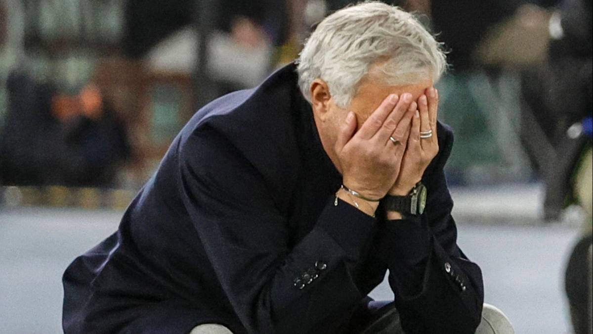 Jose Mourinho ukrywa twarz w dłoniach, wyrażając głęboki smutek lub frustrację.