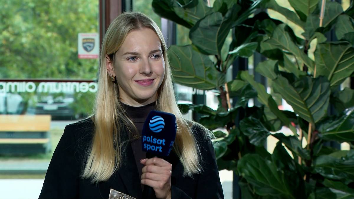 Sylwia Szczerbińska, młoda kobieta z blond włosami, trzyma mikrofon z logo Polsat Sport, uśmiecha się do kamery.