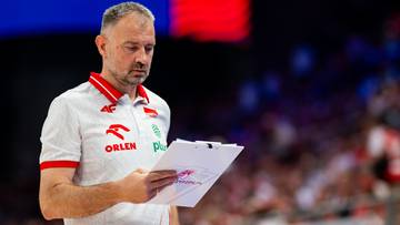 Mężczyzna w białej koszulce polo z czerwonymi elementami, trzymający notatnik i długopis, patrzy na dokumenty.