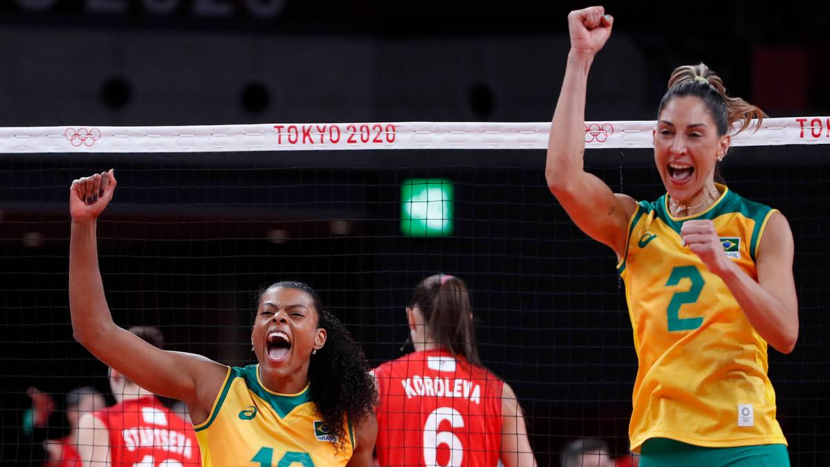 Dwie siatkarki świętujące zwycięstwo, jedna z nich unosi pięść w geście triumfu.