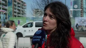 Kobieta udziela wywiadu z mikrofonem Polsat Sport przed budynkami.