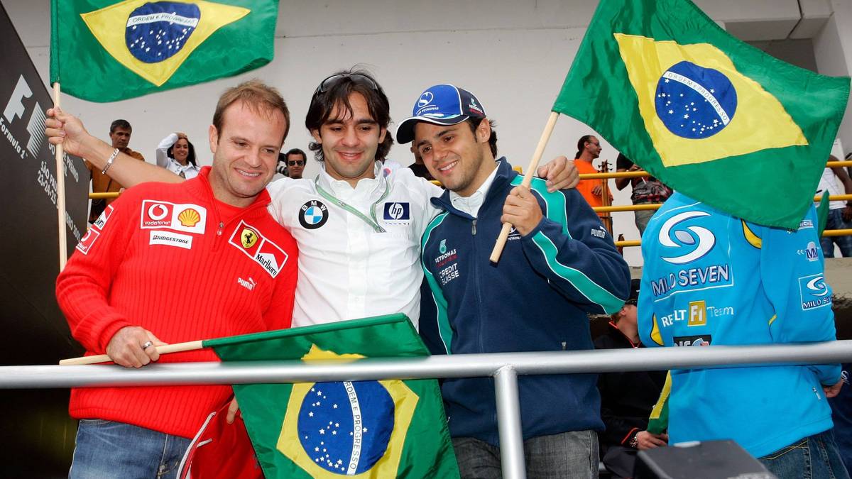 Trzech mężczyzn trzyma brazylijskie flagi podczas wydarzenia sportowego.