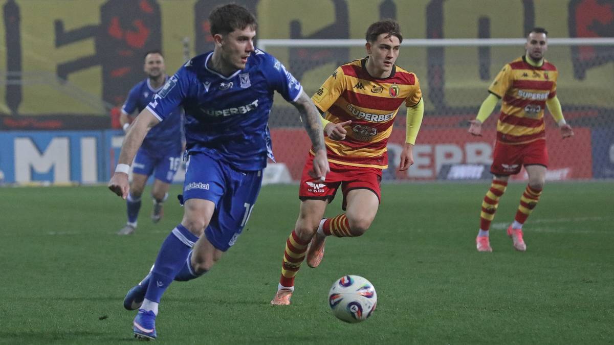 Dw&oacute;ch piłkarzy grających w piłkę nożną na boisku.