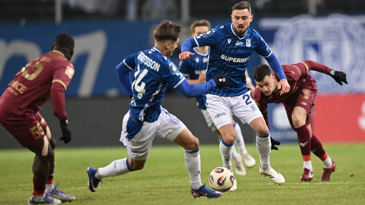 Piłkarze Lecha Poznań i Piasta Gliwice rywalizują o piłkę na murawie stadionu.
