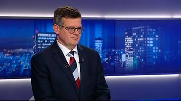 Mężczyzna w garniturze i w okularach w studio telewizyjnym