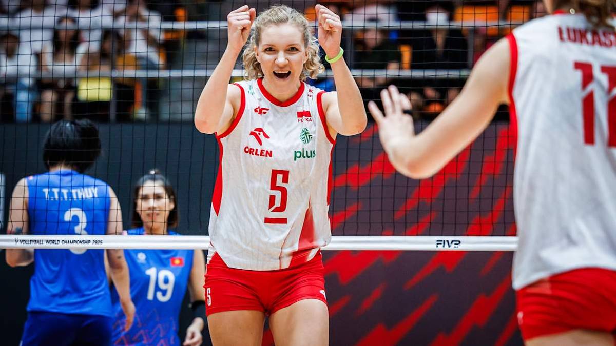 Uśmiechnięta polska siatkarka z numerem 5 na koszulce unosi ręce w geście radości, podczas meczu.