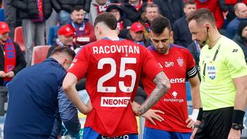 Piłkarze i sztab medyczny na boisku, jeden z zawodników leży na ziemi, otoczony przez innych.