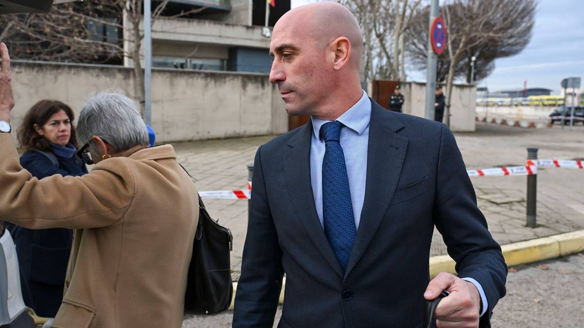 Luis Rubiales w garniturze i krawacie, idzie po chodniku, z innymi ludźmi w tle.