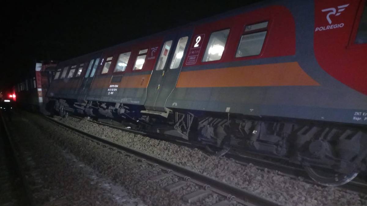 Część wykolejonego pociągu Polregio na torach nocą.