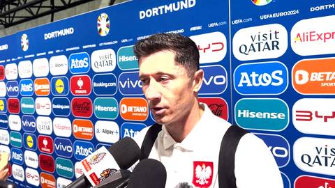 Robert Lewandowski w białej koszulce z godłem Polski udziela wywiadu przed ścianką z logotypami sponsorów i napisem DORTMUND.