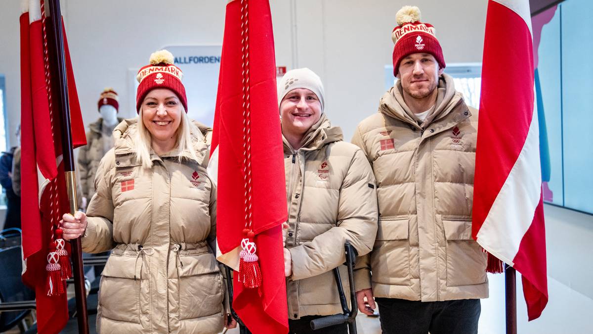 Trzy osoby w zimowych kurtkach i czapkach z pomponami trzymają duńskie flagi.