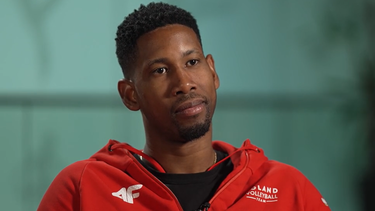 Wilfredo Leon, siatkarz w czerwonej bluzie z kapturem, patrzy w bok.