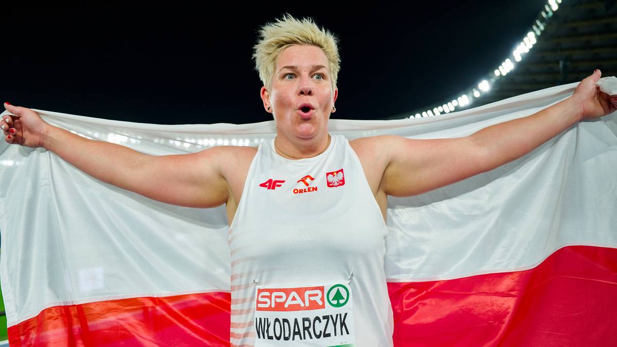 Anita Włodarczyk, polska zawodniczka, trzyma biało-czerwoną flagę, z biało-czerwoną koszulką z napisem SPAR WŁODARCZYK