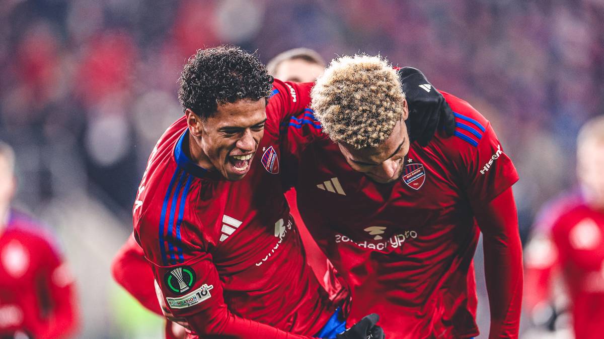 Dw&oacute;ch piłkarzy Rakowa Częstochowa w czerwonych koszulkach świętuje razem na boisku.