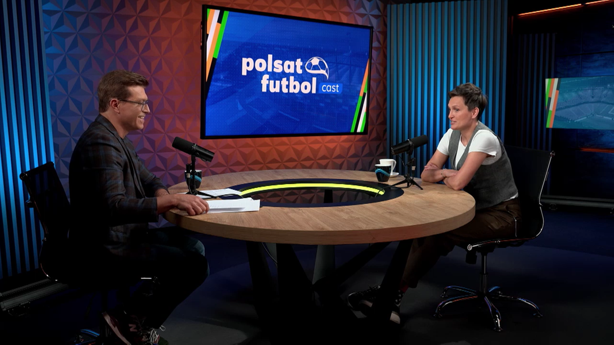 Dwie osoby siedzą przy okrągłym stole w studiu telewizyjnym, rozmawiając ze sobą. Na ekranie w tle widnieje logo programu "Polsat Futbol Cast".